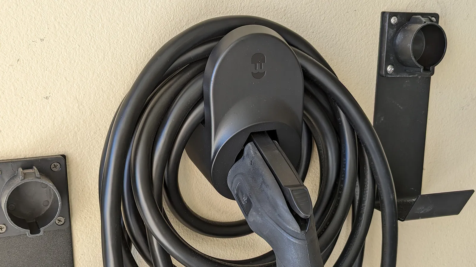 Comparison of different EV charging cable organizers on a workbench.