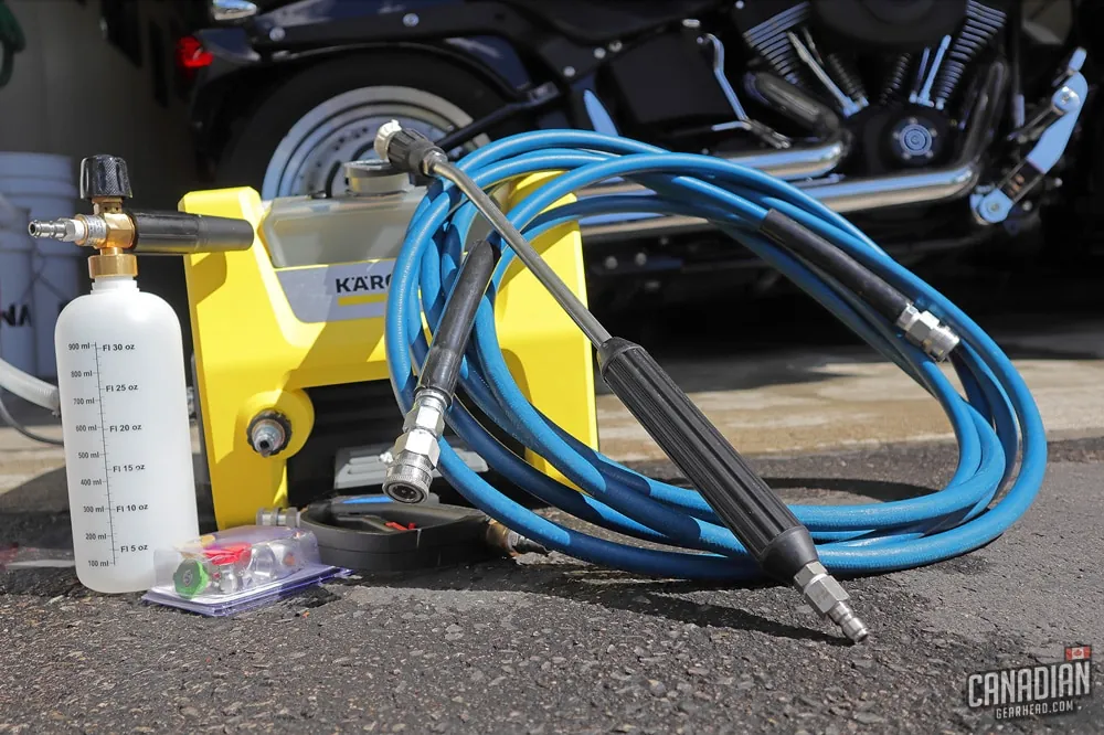 Different types of pressure washers displayed on a garage workbench.