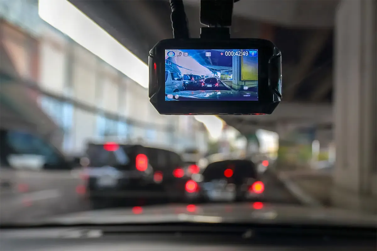 Five dash cams lined up on a car dashboard at night