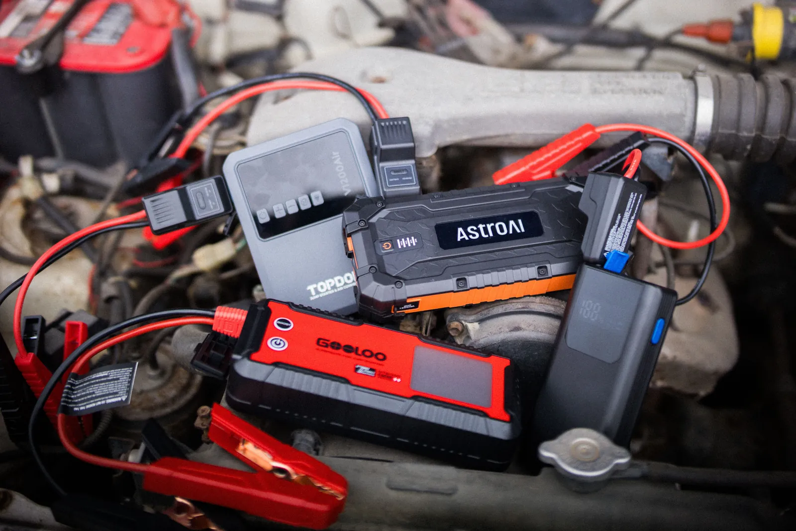 Portable battery pack with heavy cables attached to a dead car battery.