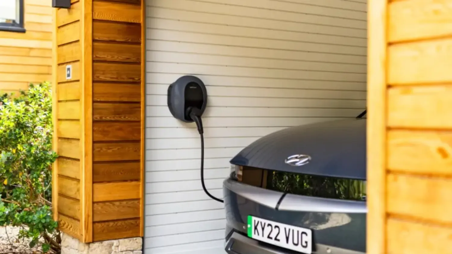 Safe home EV charging area with clear space and fire extinguisher nearby.