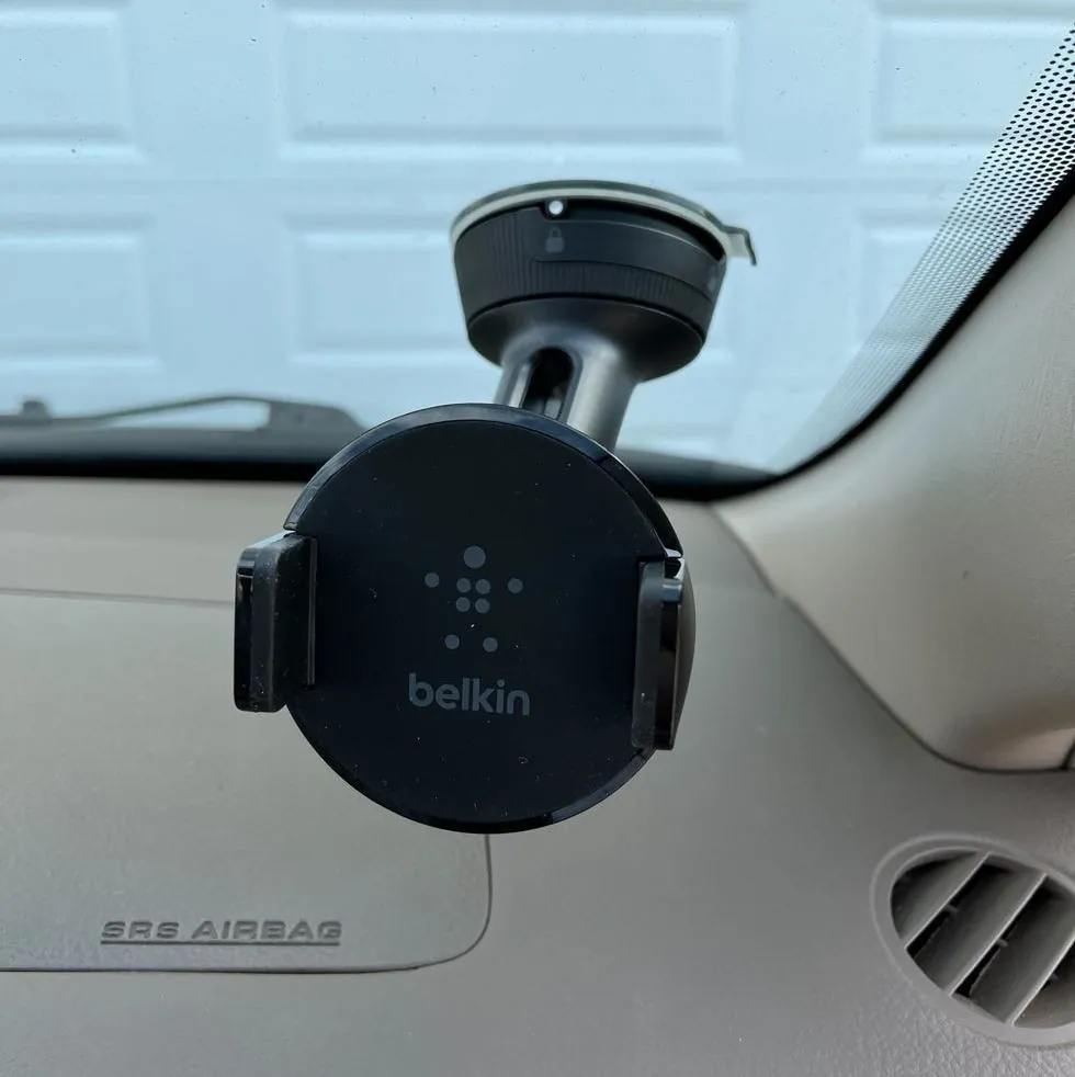 A suction cup car phone holder securely attached to a vehicle dashboard.
