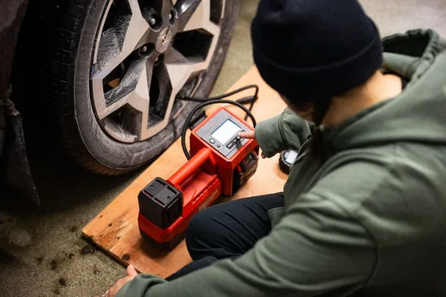 Tire inflator power plug connected to car 12V outlet socket.