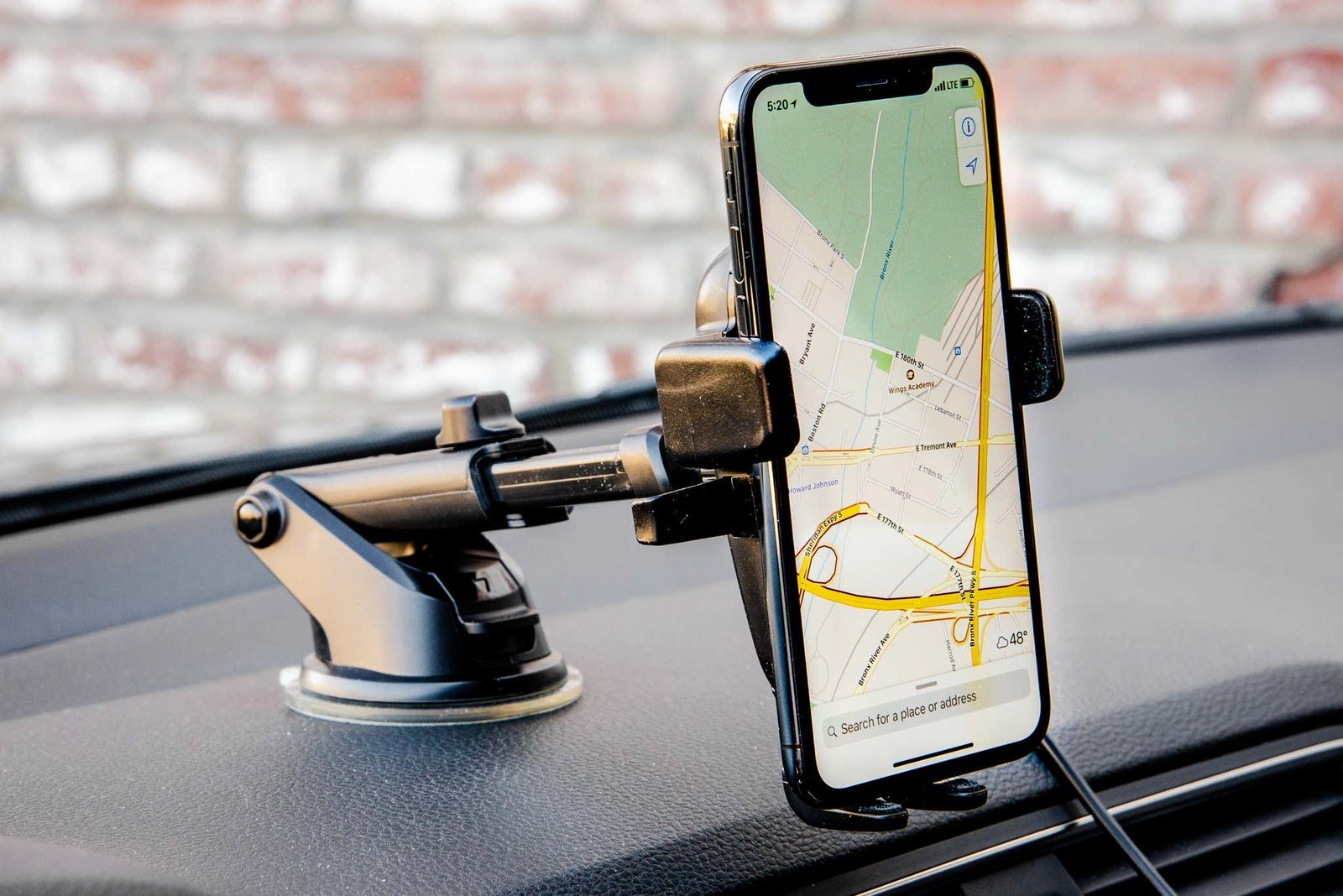 Wireless car charger mount holding smartphone on sunlit dashboard